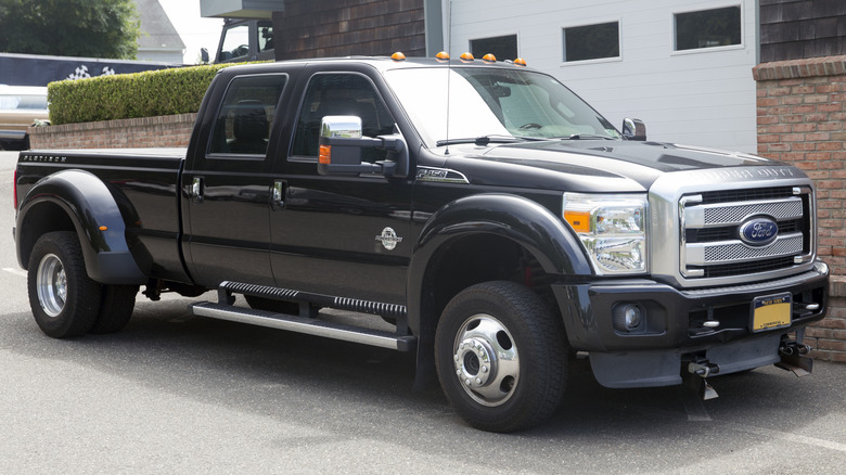Tuxedo black metallic 2014 Ford F-450 Super Duty Platinum crew cab parked next to a building