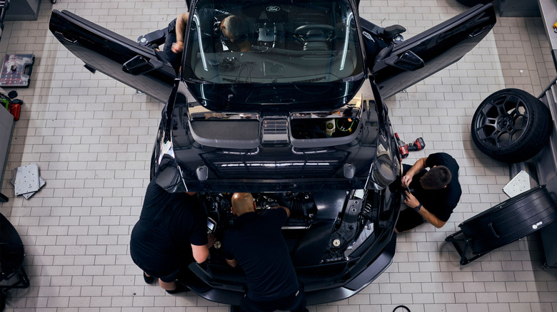 An overhead view of a black Ford Mustang GTD in a workshop