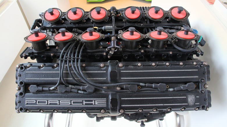 A view of the valve cover and intake setup of a Porsche Formula 1 V12 engine on a stand