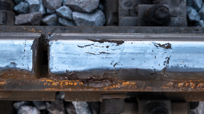 A close up of a rail road track that's damaged
