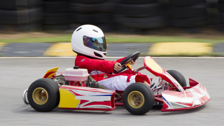 A small child racing a go-kart