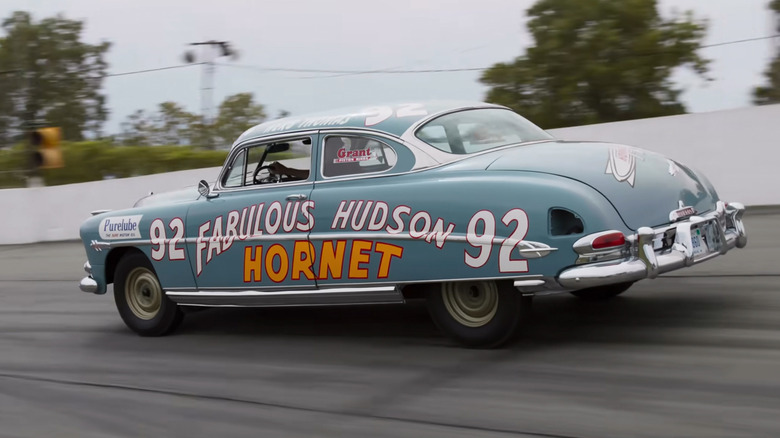 A Hudson Hornet driving on a racetrack.