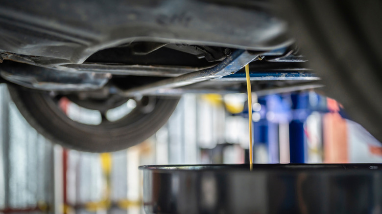 Fluid being drained from underneath a car.