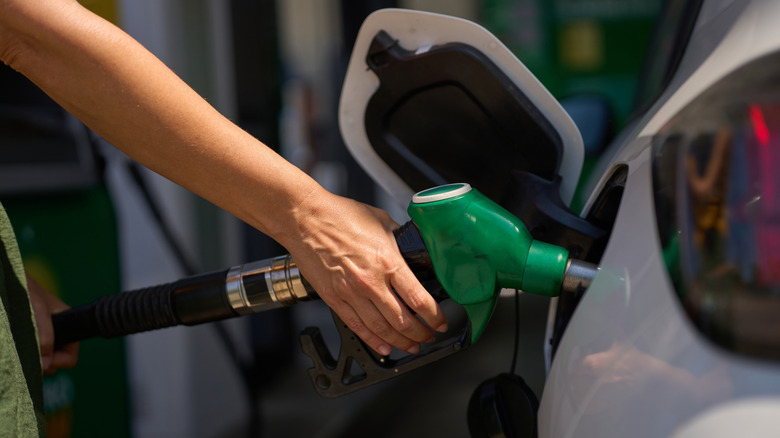 A woman filling her car up with gas