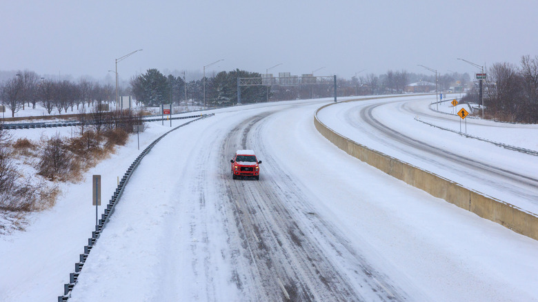 A truck heads south on Interstate 69 in snowy weather