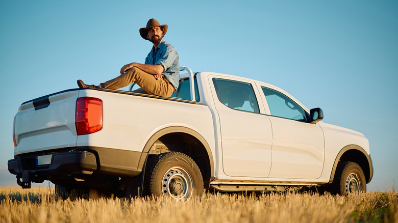 A man relaxing on the bed of a pickup truck