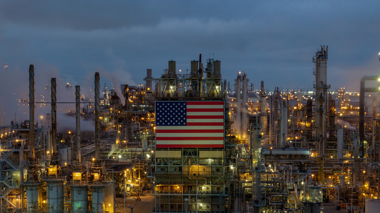 An image of an oil refinery in L.A. with a huge American flag displayed
