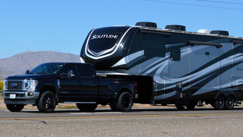 A Ford F-350 Super Duty diesel truck towing a fifth-wheel trailer on the highway