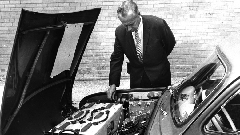 Man looking under the hood of a Henney Kilowatt EV in 1966.