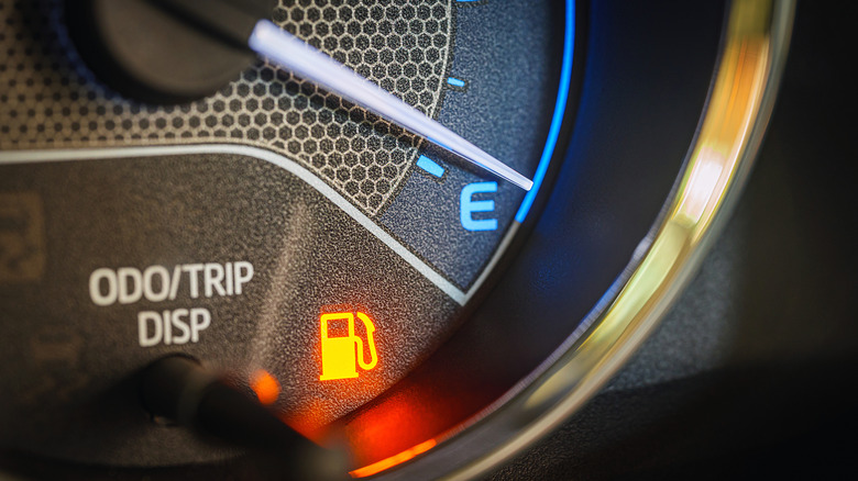 A low fuel light comes on as a vehicle runs low on available gasoline