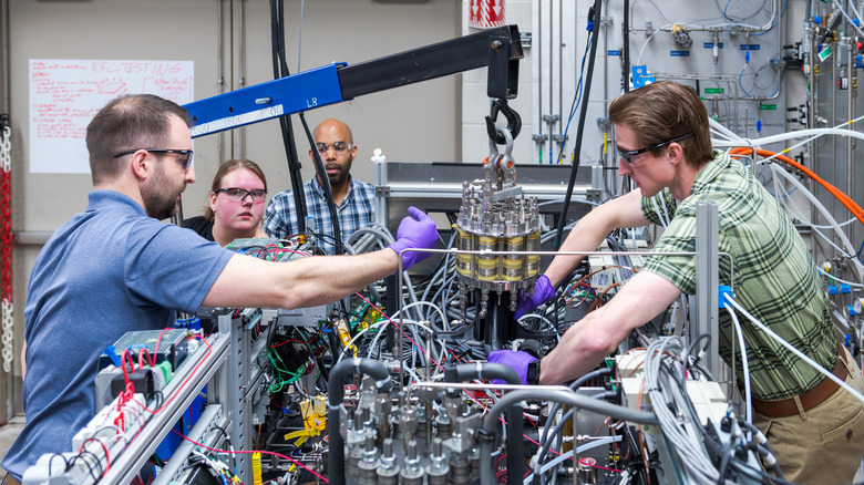 From left to right, Dr. Kerrigan Cain, Jessica Cashman, Dr. Devon Powers, and Ryan Grotenrath install a fuel cell onto the regenerative fuel cell system inside NASA Glenn Research Center's Fuel Cell Testing Laboratory in Cleveland on Feb. 23, 2026.