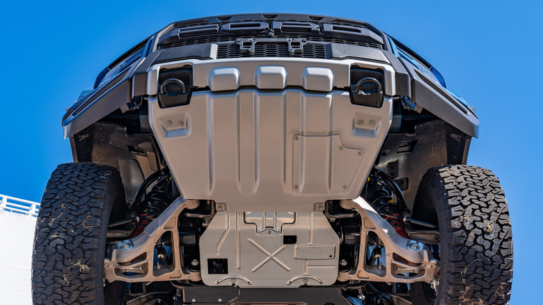 The underside of a Ford F-150 Raptor with a large silver skid plate