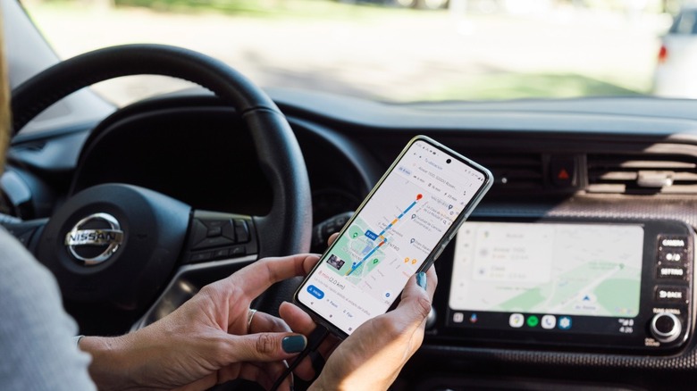 A smartphone connected to Android Auto by USB