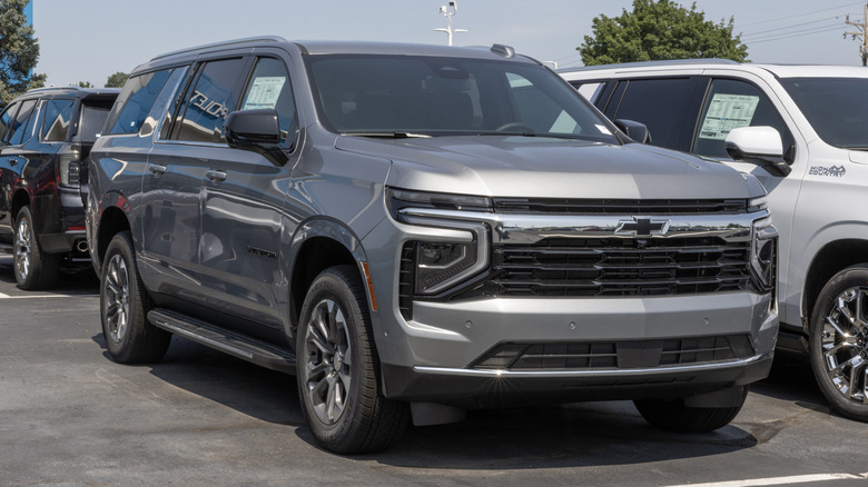 A gray Chevrolet Suburban parked on a dealership lot.