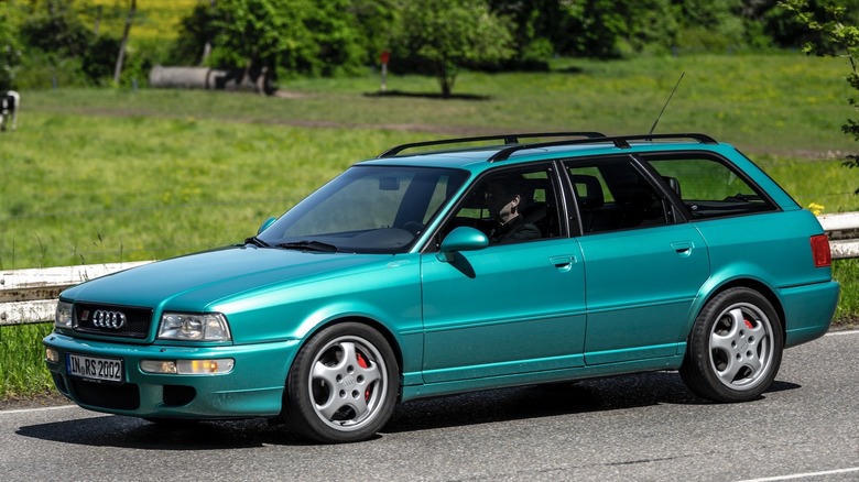 A green Audi RS2 cruising along showing its front three-quarter view on a sunny day.
