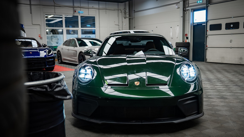 Dark green Porsche 911 GT3 Touring sitting in a Porsche workshop