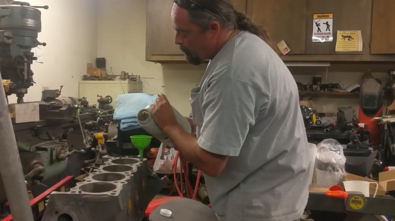 A man adding block-filler to his engine