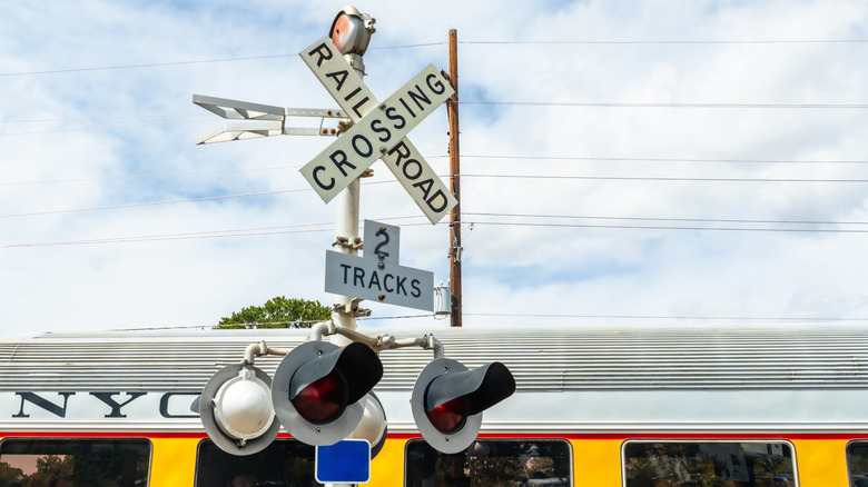 A crossbuck sign with lights at a railroad crossing