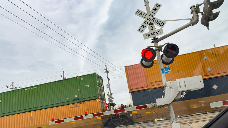 A railroad crossing with lights warning motorists of a passing train