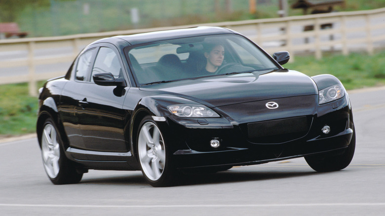 A black 2004 Mazda RX-8 entering a curve