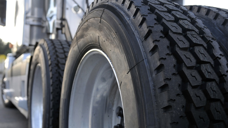 A closer view of a semi truck's drive tires with chunkier treads and a more rugged design