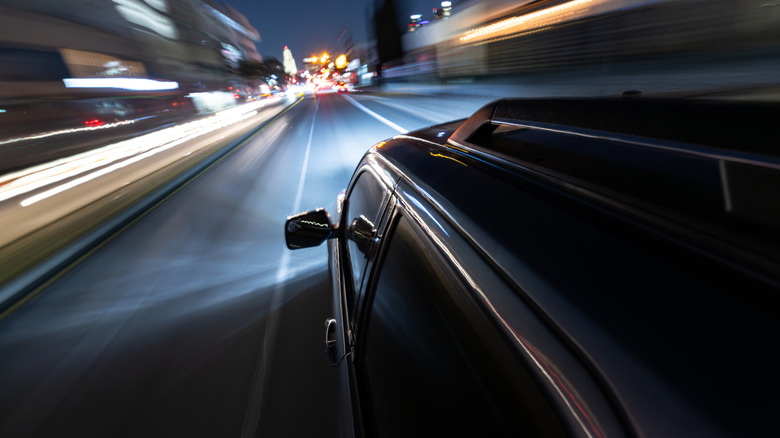 A long exposure shot in an urban environment of a car driving down the road.