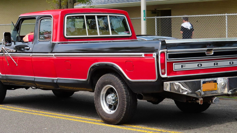 Red and black mid-1970s Ford truck with two gas tank doors on left side