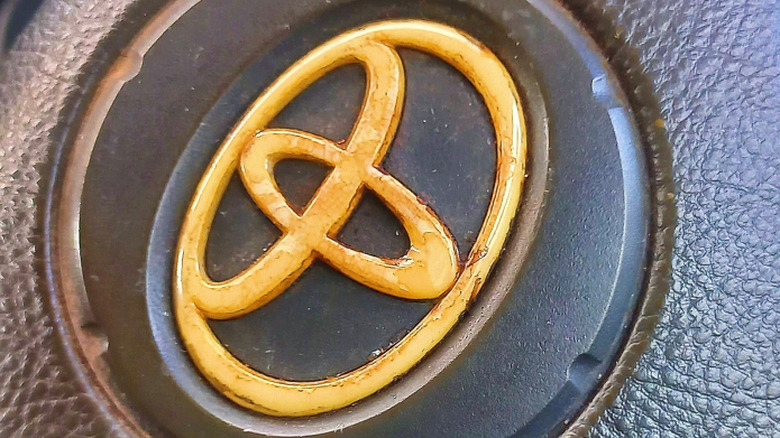 A gold Toyota logo on a steering wheel