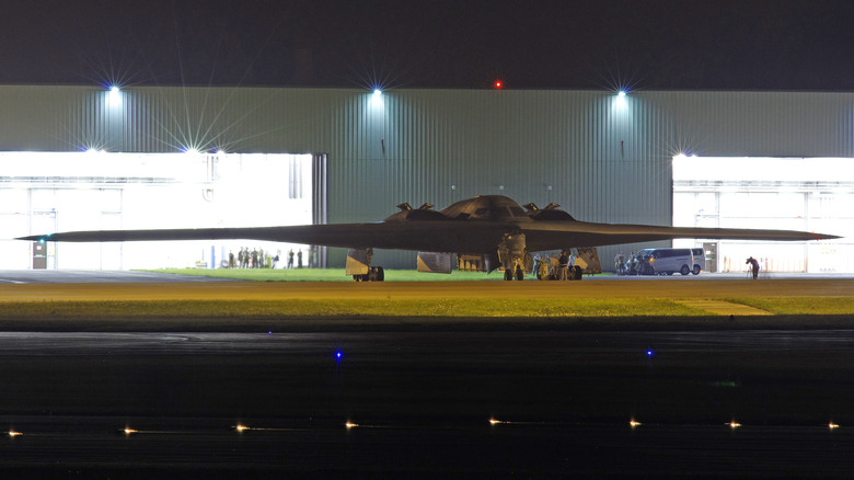 A B-2 Spirit outside of a hangar at night.
