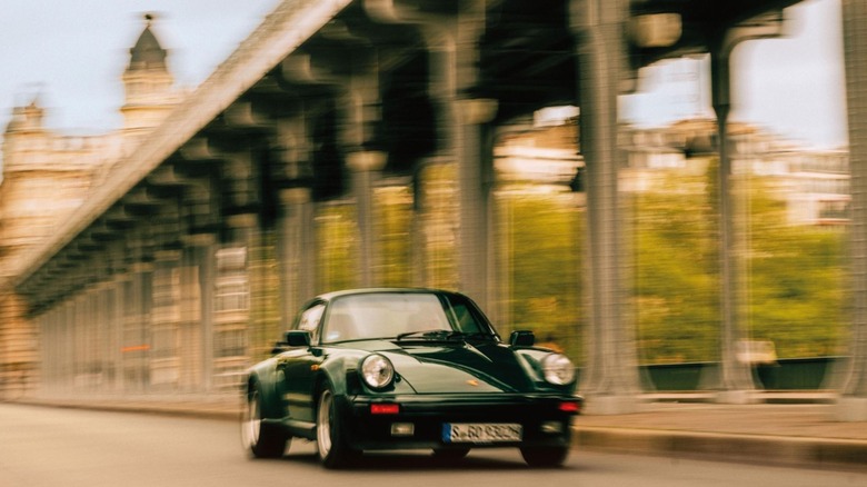 A black Porsche 930 driving through Paris