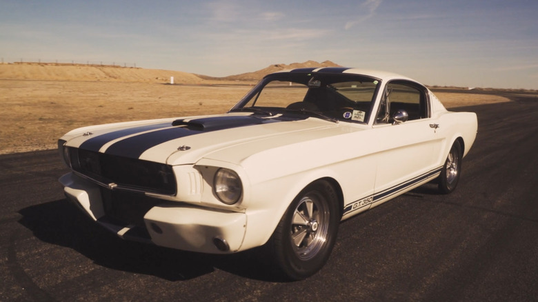 A Wimbledon White Mustang GT350 parked on an empty track in the desert