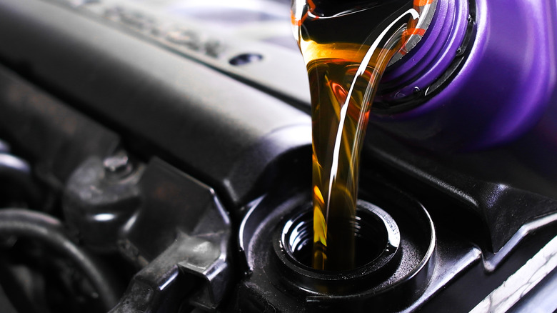 Pouring fresh oil into a car's engine