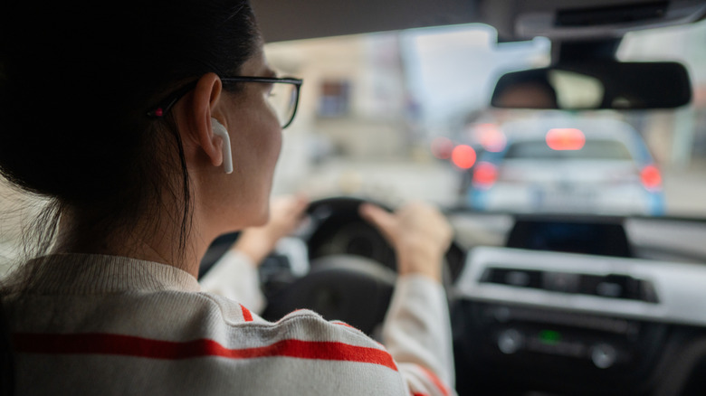 Woman driving with an earphone in