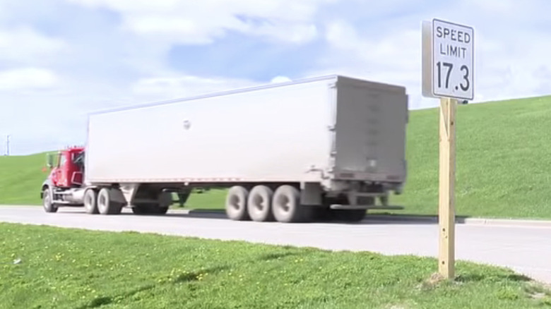 A photo of the 17.3 mph speed limit sign with a truck passing by