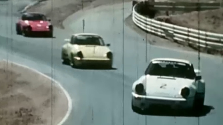 Three historic Porsche 911 race cars with fully covered and blacked-out headlamps.