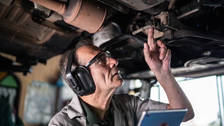 A technician checking the underbody of a truck