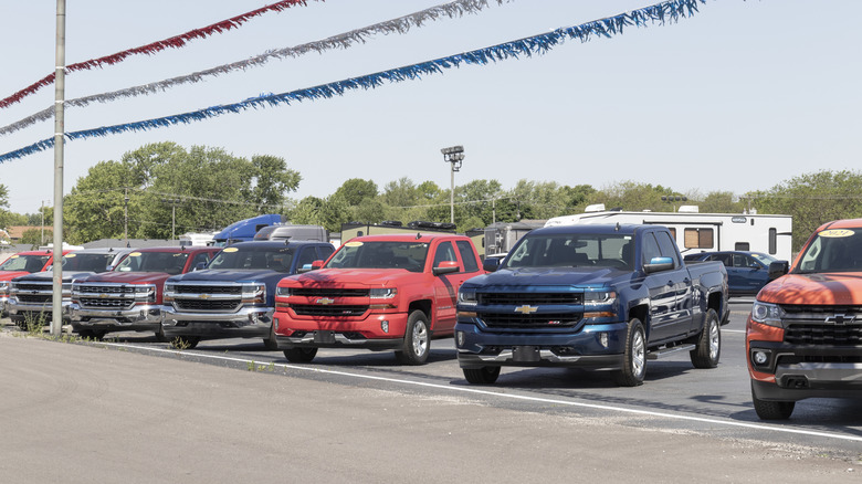 A row of pickup trucks parked at a used car lot
