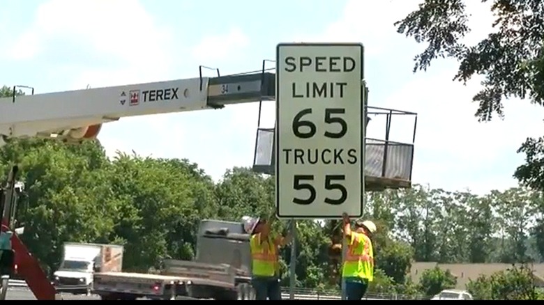 A differential speed limit sign reading 65 for the speed limit, 55 for trucks being installed