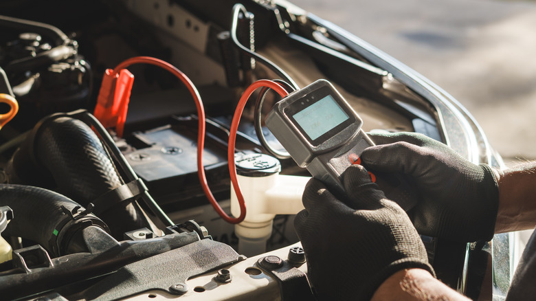 An automotive technician tests a car's battery for its health