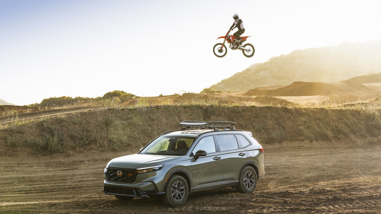 A dirt bike jumping behind a Honda CR-V