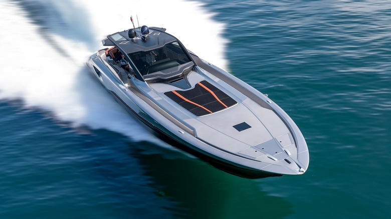A luxury yacht speeding through the ocean under a partly cloudy sky.