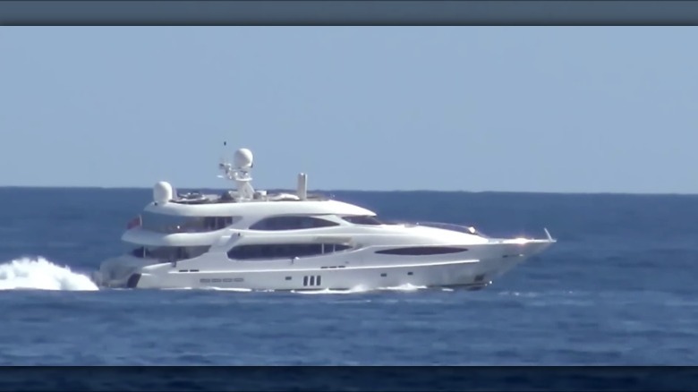 A yacht named World Is Not Enough running at cruising speed out on the open ocean on a sunny day.