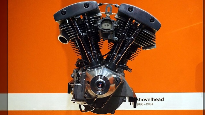 A Harley-Davidson Shovelhead engine sits against an orange background.