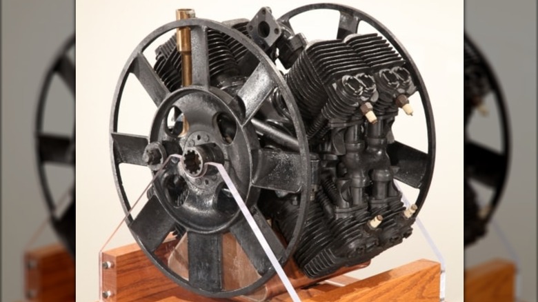 A prototype Ford X08 engine on display with one of its cooling fans and four of its spark plugs visible.