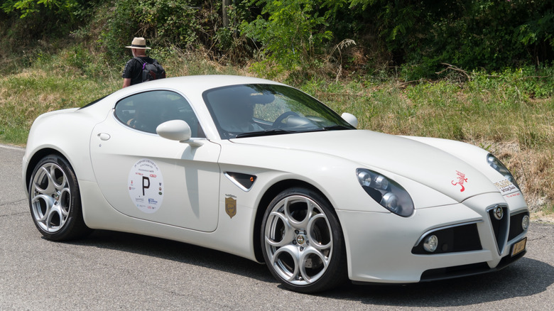 A white Alfa Romeo 8C parked near the woods