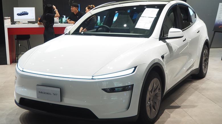 A white Tesla Model Y L on display at auto show