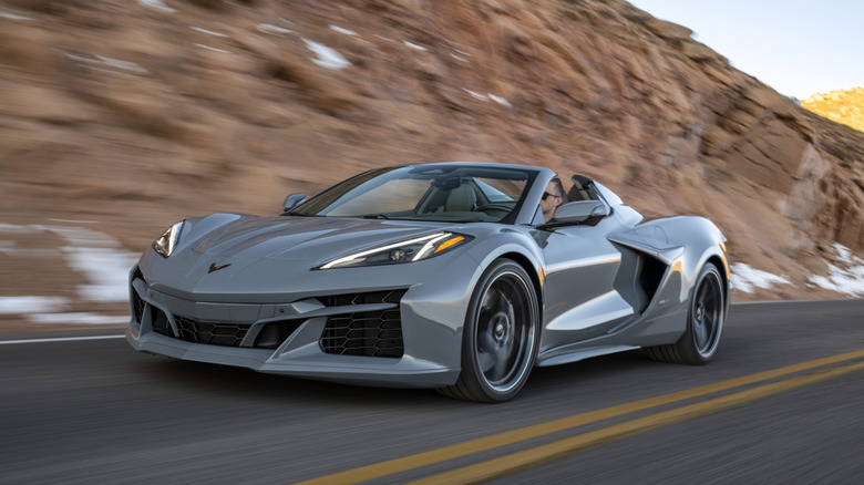 The front 3/4 of pre-production 2024 Corvette E-Ray 3LZ convertible in Sea Wolf Gray Tricoat driving on a mountain road