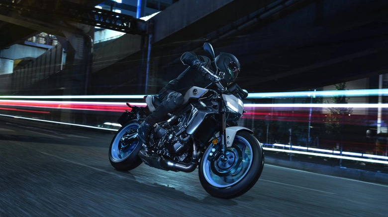 2025 Yamaha MT-09 front 3/4 view with rider cornering at speed