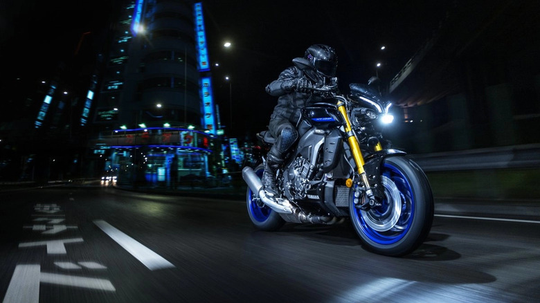 2025 Yamaha MT-10 SP front 3/4 view with rider dynamic nighttime image