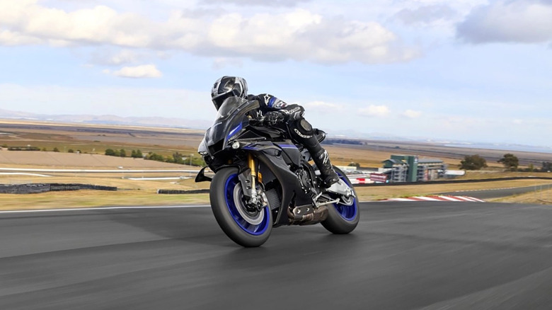 Yamaha YZF-R1M with rider cornering at speed front 3/4 view
